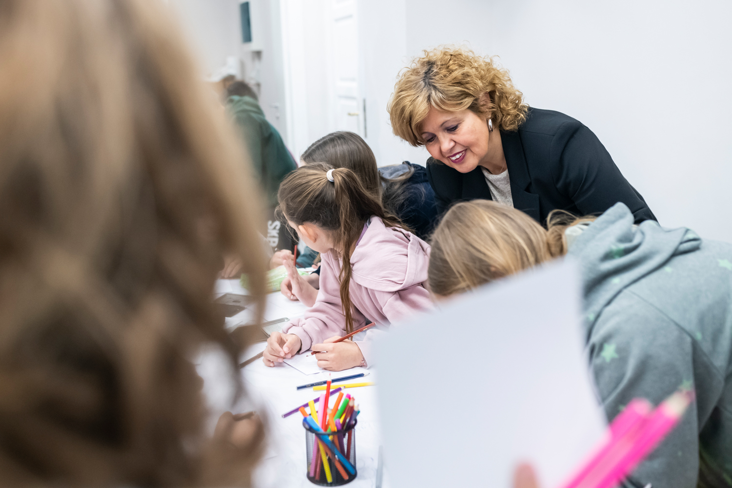 Η Δρ Δήμητρα Τσαγκάρη παρατηρεί τις ζωγραφιές μαθητριών. Εργαστήριο στο Πνευματικό Κέντρο Άμφισσας