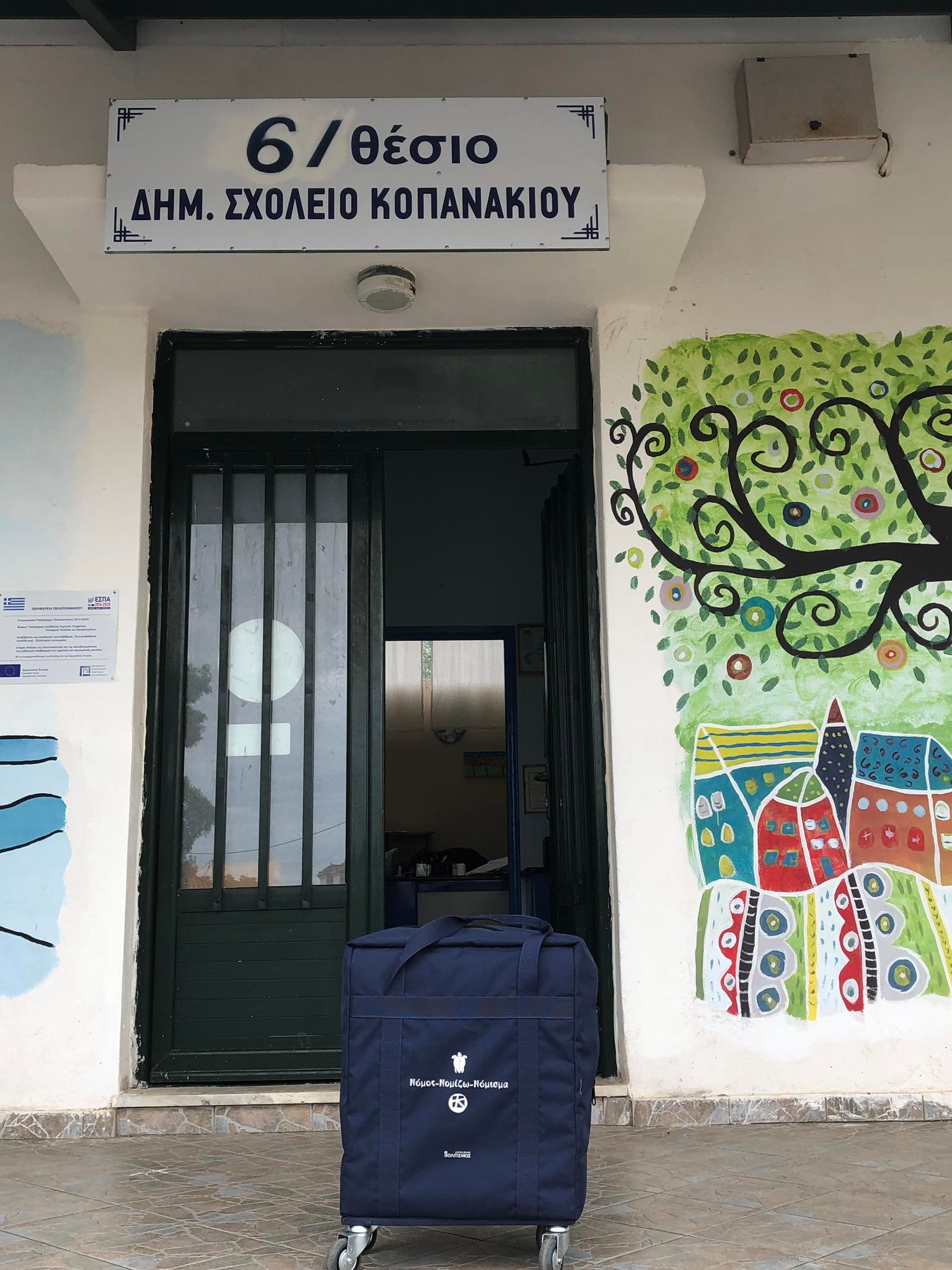 Η μουσειοβαλίτσα τοποθετημένη δίπλα από την είσοδο και κάτω από την επιγραφή του σχολείου. Δημοτικό Σχολείο Αγίου Γεωργίου Βοιωτίας