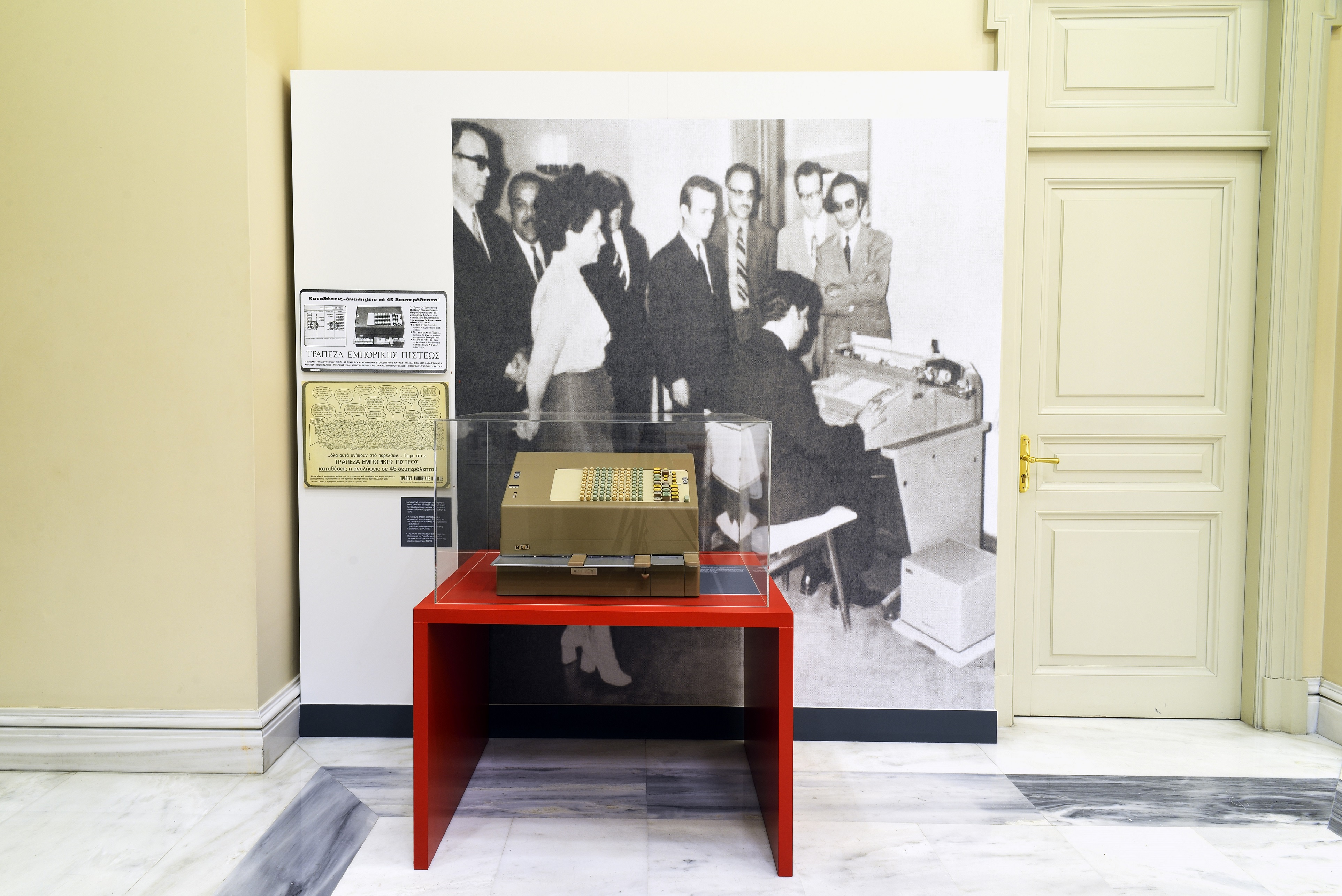 Μηχανή ταμιευτηρίου σε προθήκη. Μηχανή ταμιευτηρίου της έκθεσης «Alpha Bank Ιστορία II. Τράπεζα Εμπορικής Πίστεως, 1947-1972»