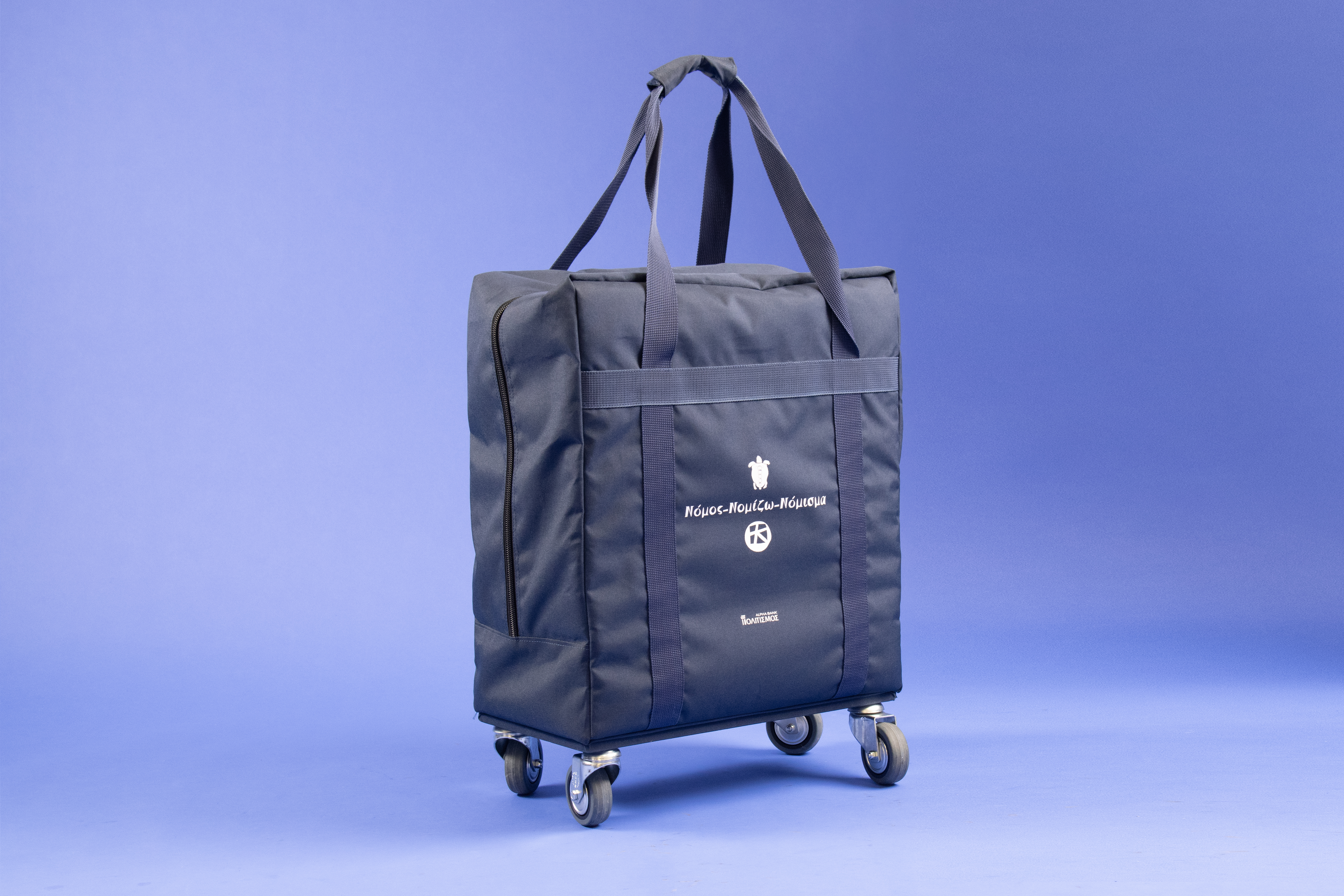 Η μουσειοβαλίτσα, σε σκούρο μπλε χρώμα, όρθια στις ρόδες της.