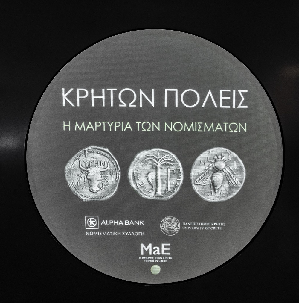 Λογότυπο με 3 νομίσματα εντός κυκλικού πλαισίου. Αναγράφεται ο τίτλος Κρητών Πόλεις. Η μαρτυρία των νομισμάτων.  Λογότυπος «Κρητών πόλεις. Η μαρτυρία των νομισμάτων»