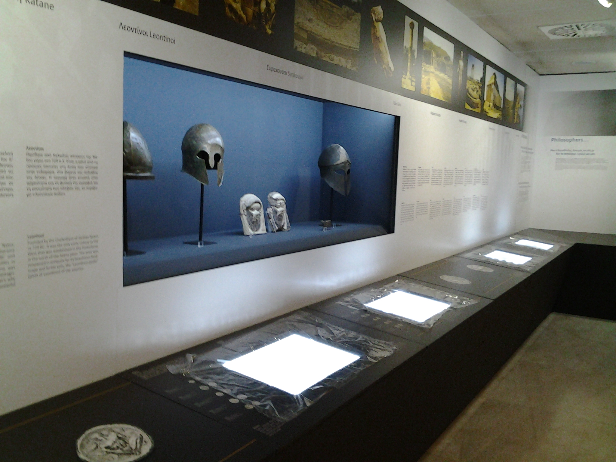 The exhibition area with exhibits in illuminated cases.  Exhibits “The Europe of Greece”