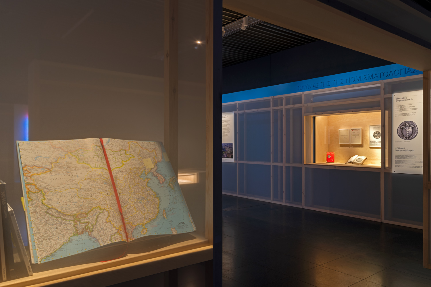 Display cases with an atlas and books containing notes handwritten by Yannis Costopoulos. Yachtsman section